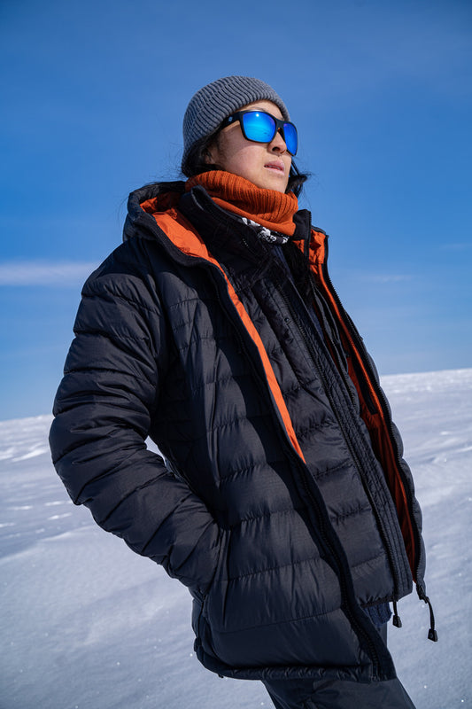 Woman standing in Arctic wearing Blue sunglasses